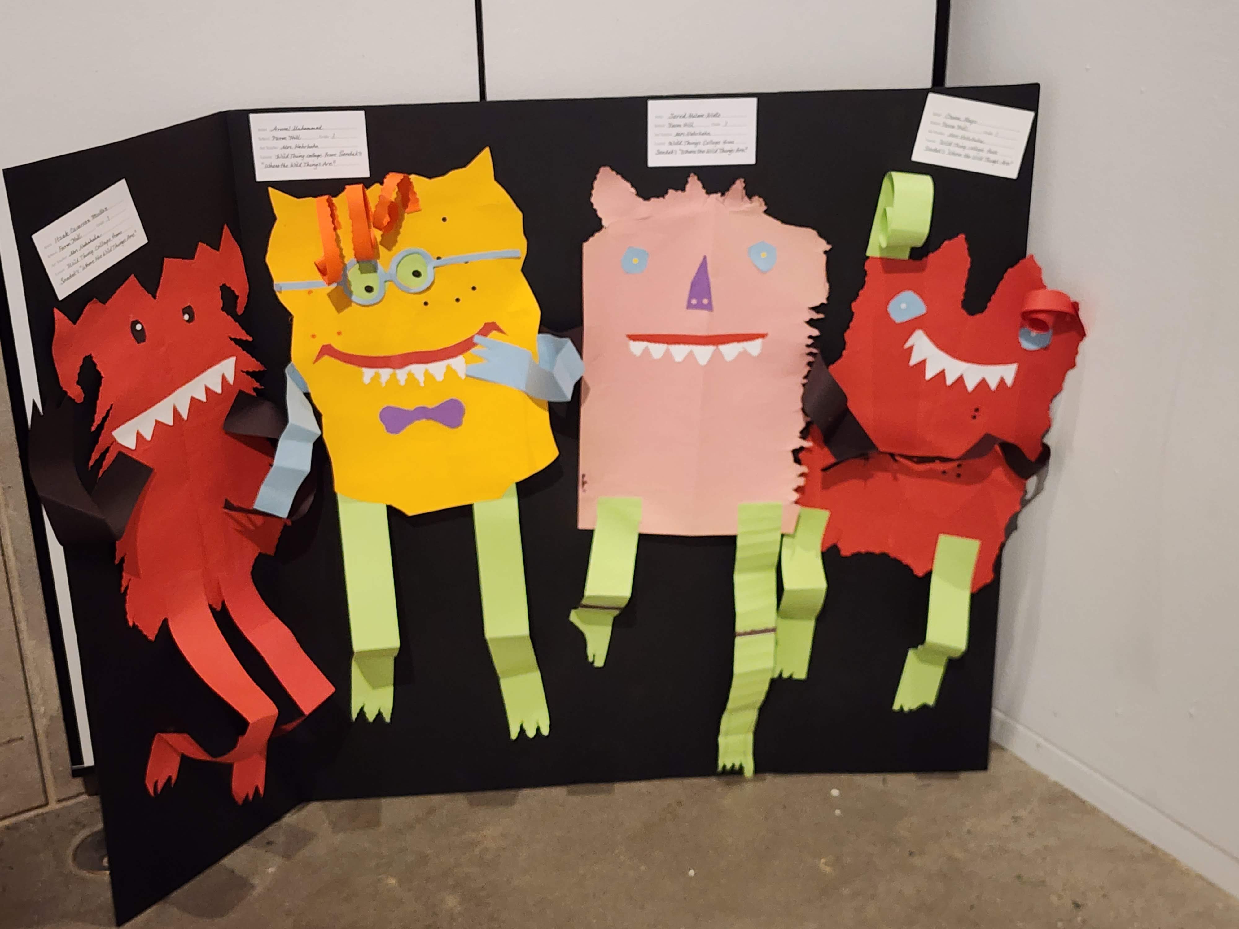 A piece of student artwork featuring four colorful monster-like characters
